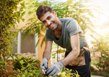 retrato al aire libre de granjero sonriendo trabajando con herramientas de jardin
